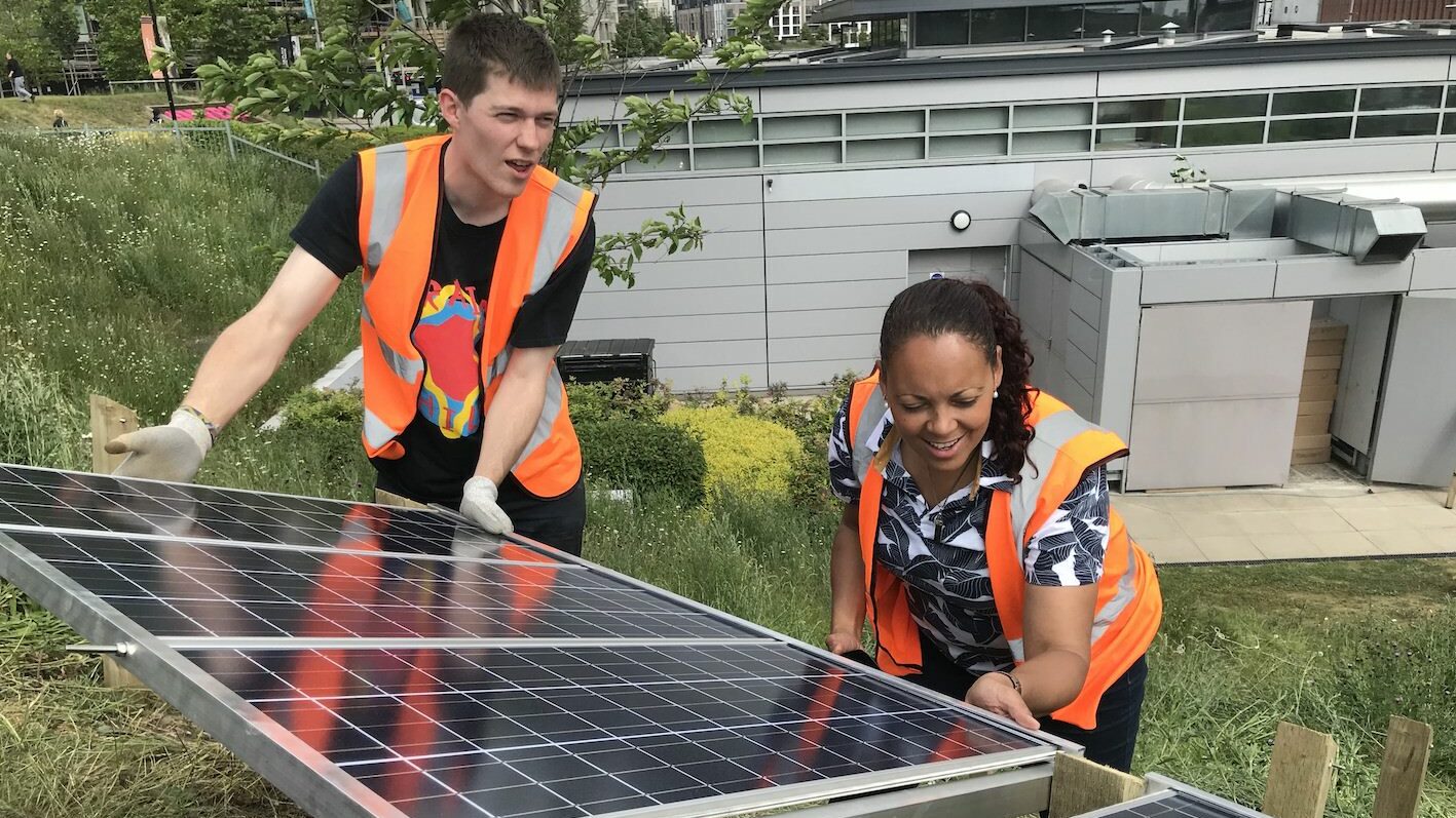 El personal de Wholegrain Digital instala paneles solares para generar su propia energía renovable