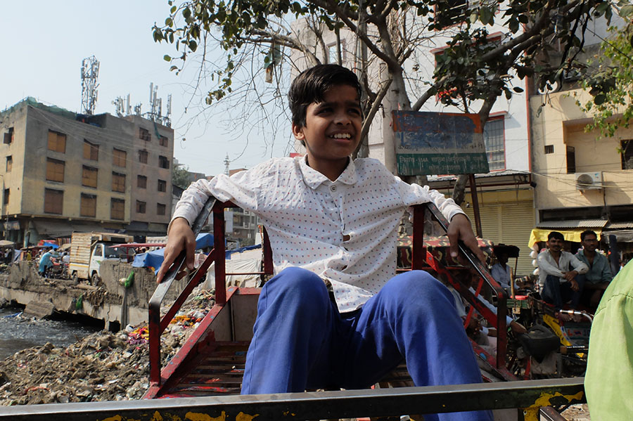Young boy plays, smiling as he is unaware of the toxins around him