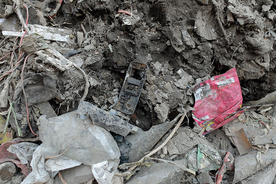 Discarded smartphone case abandoned among forgotten trash and debris
